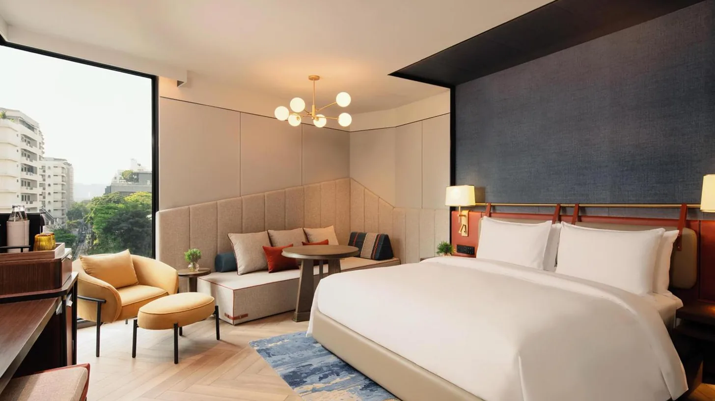 a bedroom with a large bed and a living room at Canopy By Hilton Bangkok Sukhumvit in Bangkok