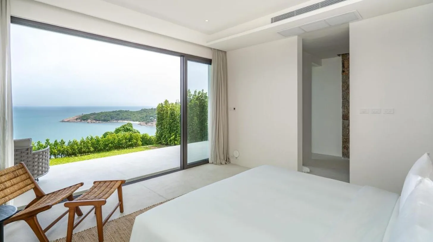 a bedroom with a large bed and a view of the ocean at Cape Azure Resort Samui by Thalsea in Plai Laem