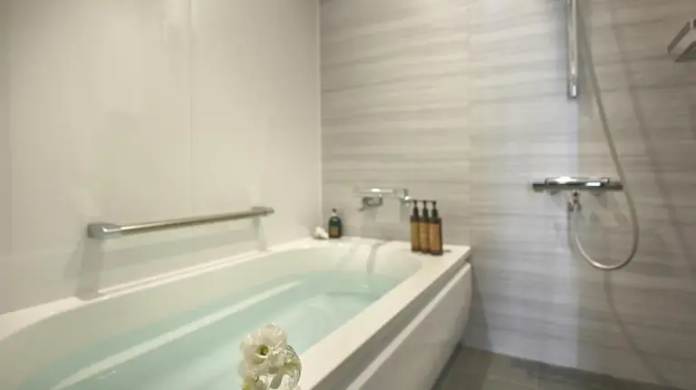 a white bathroom with a tub and a shower at Centara Grand Hotel Osaka in Osaka