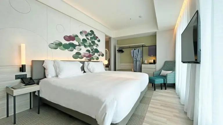 a hotel room with a large bed and a television at Centara Grand Hotel Osaka in Osaka