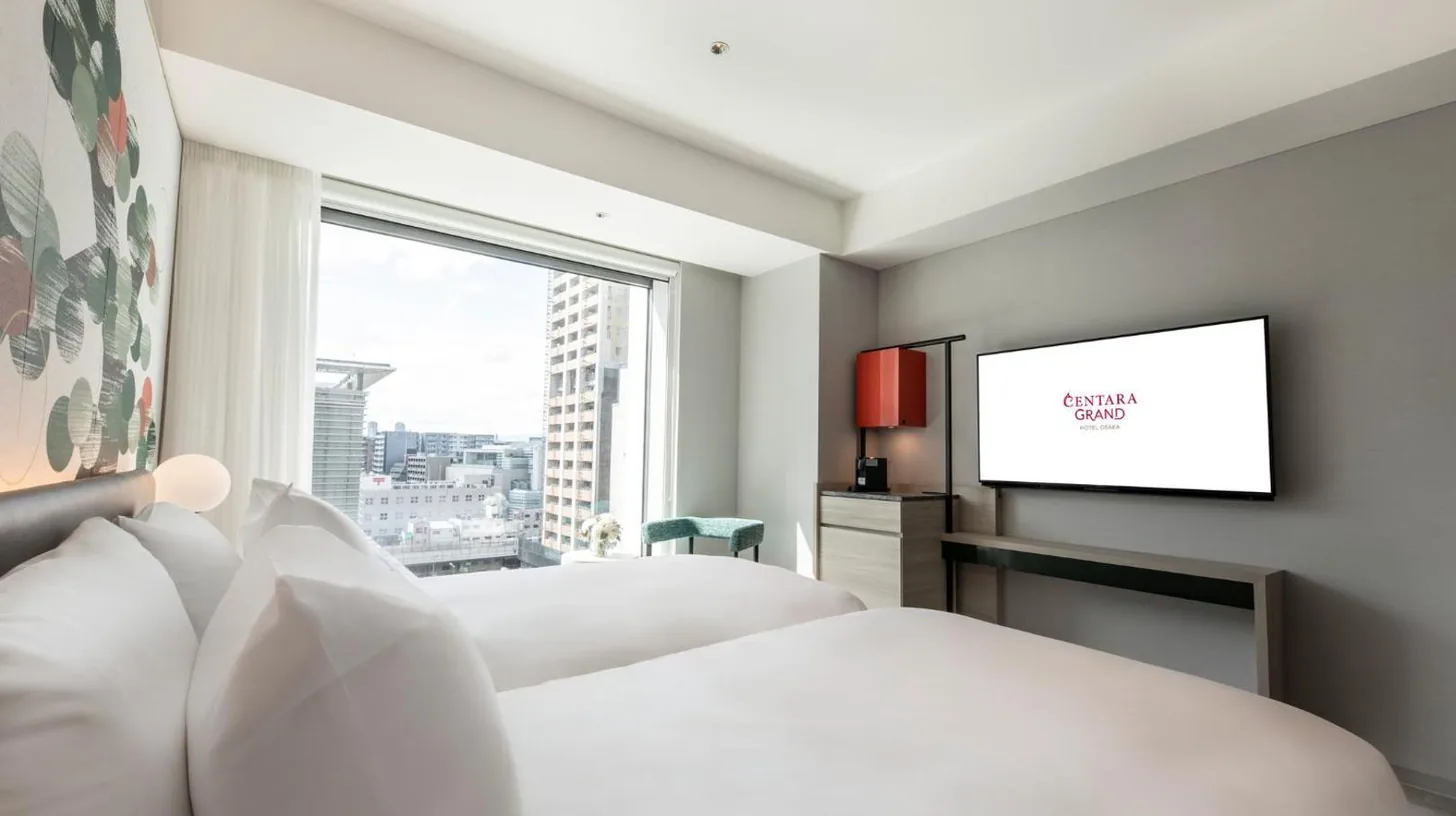 a bedroom with two beds and a flat screen tv at Centara Grand Hotel Osaka in Osaka