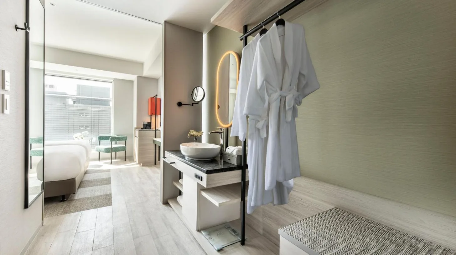 a bedroom with a large bed with a large window at Centara Grand Hotel Osaka in Osaka