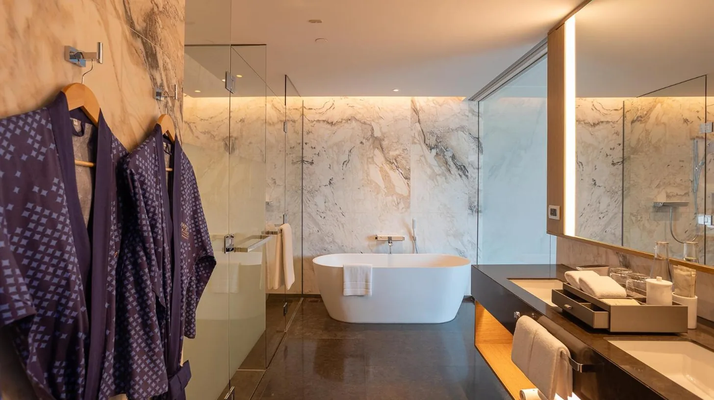 a bathroom with a white tub and a sink at Chatrium Grand Bangkok in Bangkok