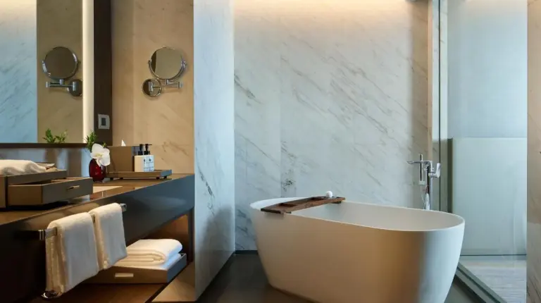 a bathroom with a tub and a sink at Chatrium Grand Bangkok in Bangkok