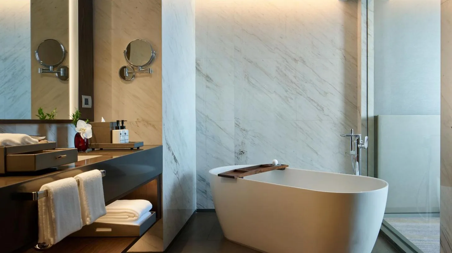 a bathroom with a tub and a sink at Chatrium Grand Bangkok in Bangkok
