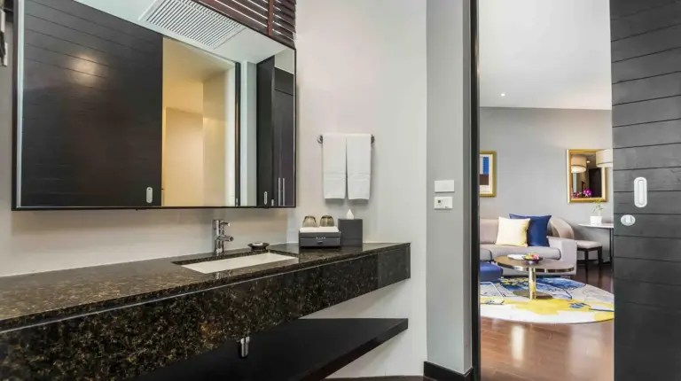 a bathroom with a sink and a mirror at Chatrium Hotel Riverside Bangkok in Bangkok
