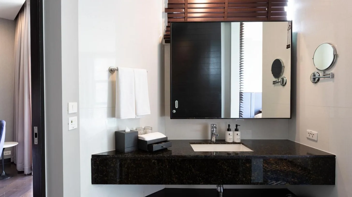 a bathroom with a toilet and a shower at Chatrium Hotel Riverside Bangkok in Bangkok