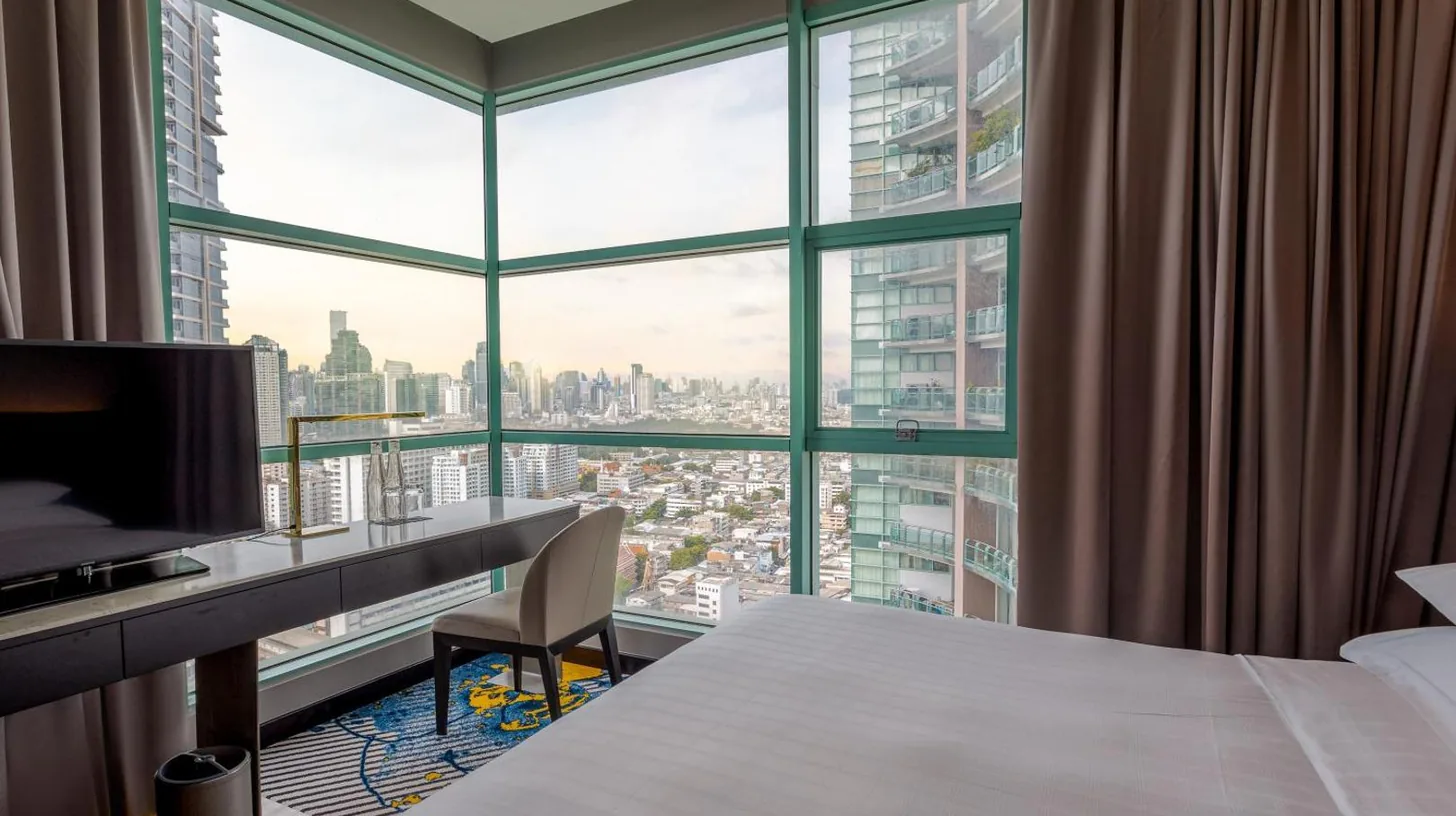 a kitchen with a stainless steel refrigerator and a sink at Chatrium Hotel Riverside Bangkok in Bangkok