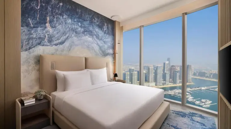 a table in a hotel room with a blue chair at Ciel Dubai Marina
