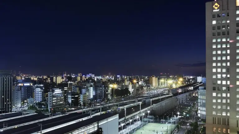 a view of a city at night with a clock tower at Courtyard by Marriott Shin-Osaka Station in Osaka