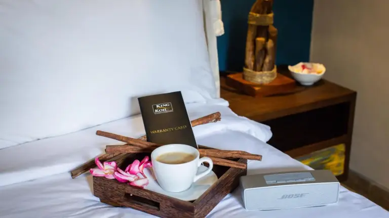 a tray with a cup of coffee and a book on a bed at Delight ART Villas in Seminyak