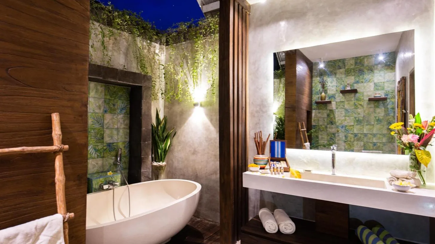 a bathroom with a tub and a large mirror at Delight ART Villas in Seminyak