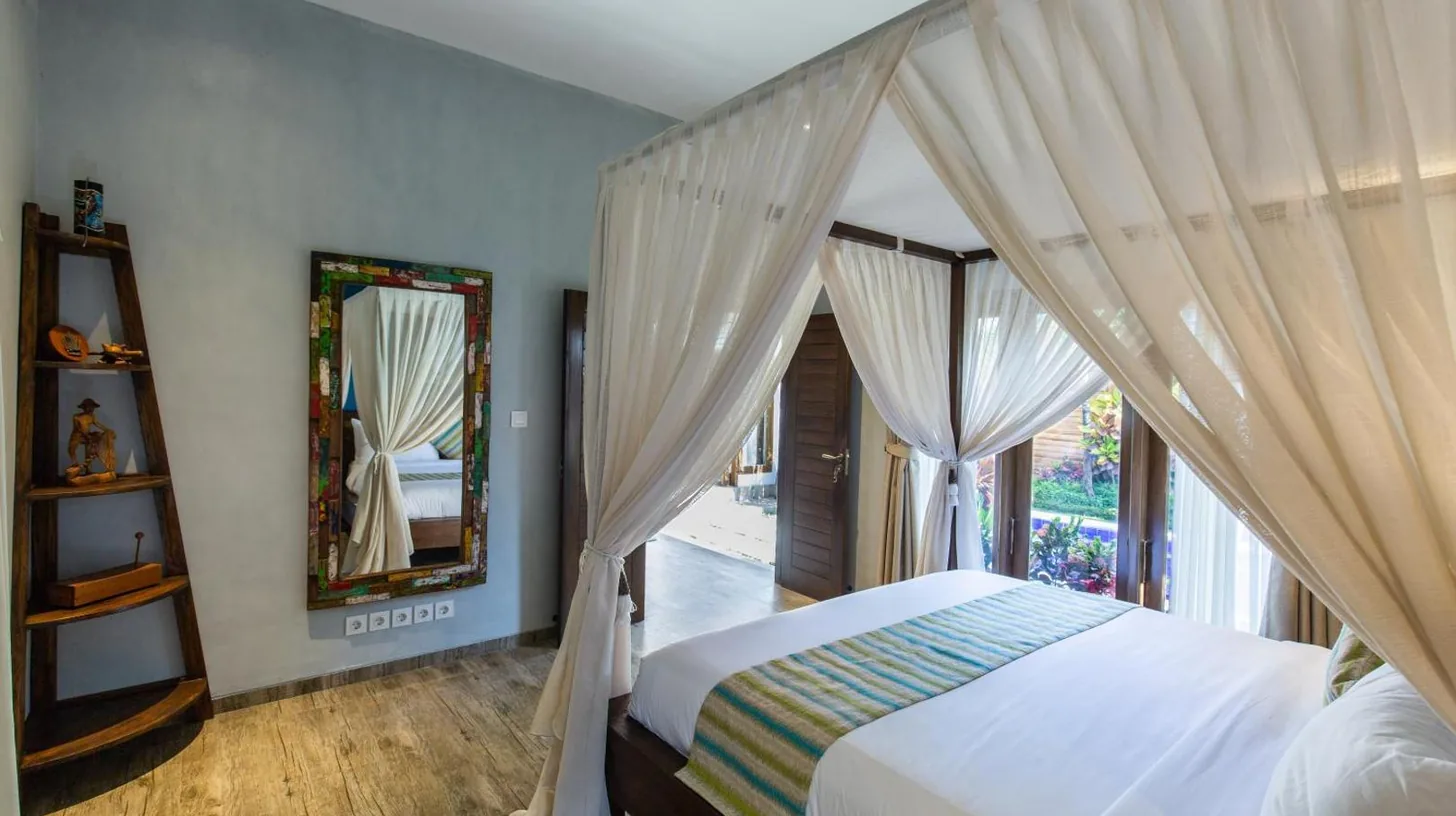 a bedroom with a canopy bed and a mirror at Delight ART Villas in Seminyak