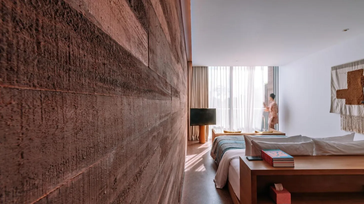 a bedroom with a brick wall next to a bed at Desa Potato Head Bali in Seminyak