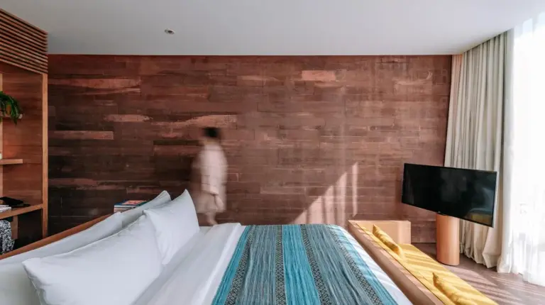 a bedroom with a bed and a brick wall at Desa Potato Head Bali in Seminyak