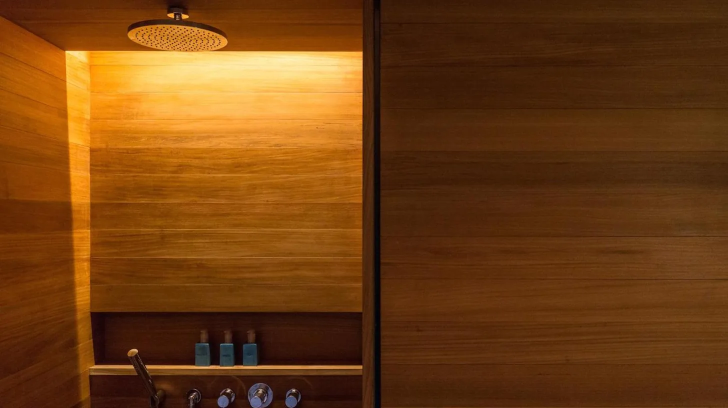 a wooden cabinet with a light in a room at Desa Potato Head Bali in Seminyak