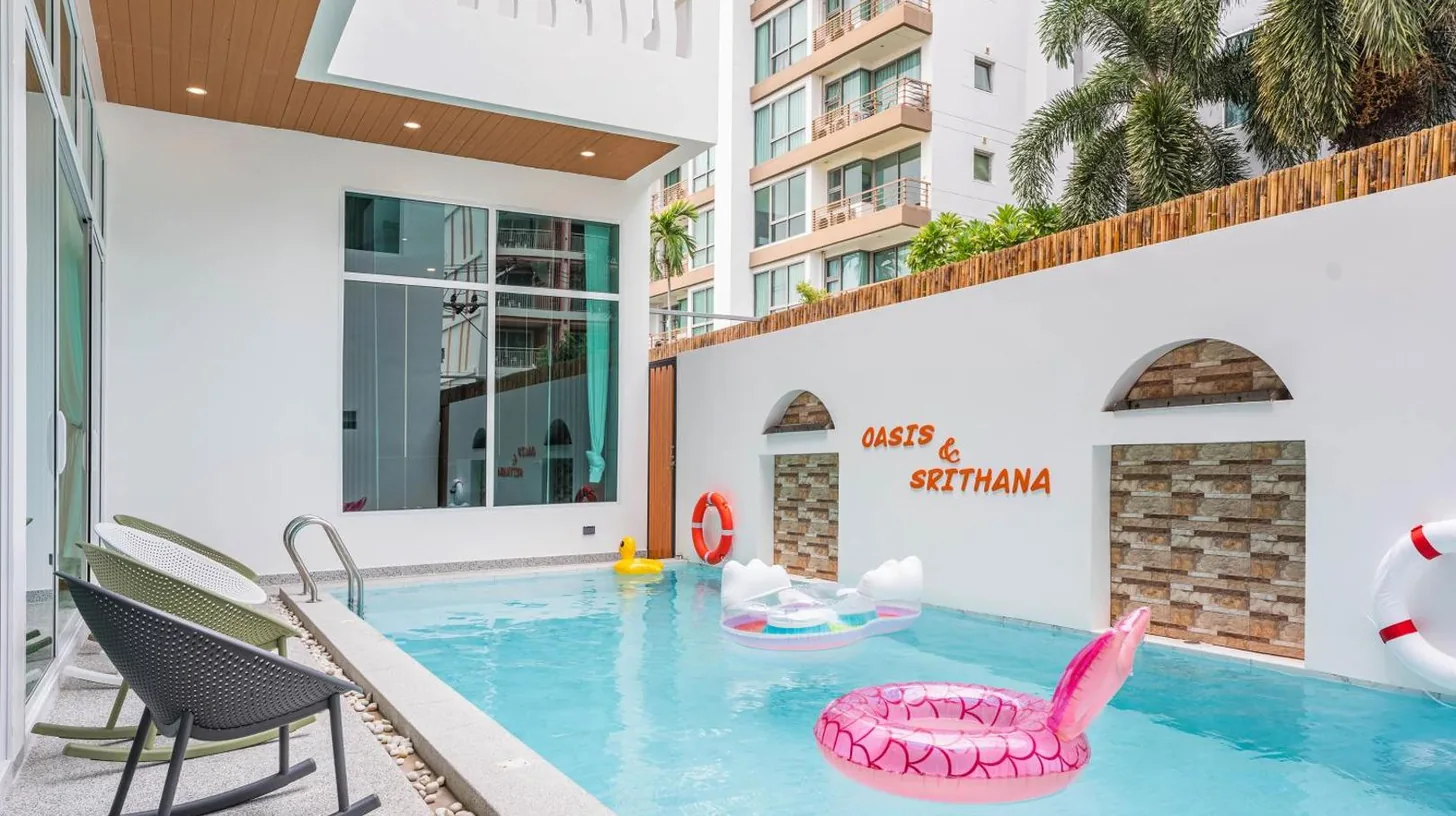 a pool at a hotel with a pink inflatable chair at Downtown Oasis 芭提雅市中心独栋泳池别墅 A 5卧6卫 KTV BBQ 芭提雅海滩步行街500m in Pattaya South