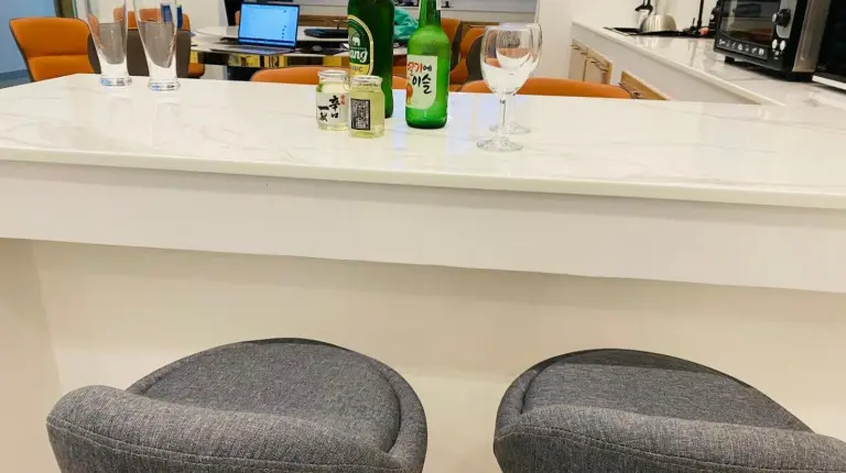 a bar with two bottles of wine and two chairs at Downtown Oasis 芭提雅市中心独栋泳池别墅 A 5卧6卫 KTV BBQ 芭提雅海滩步行街500m in Pattaya South