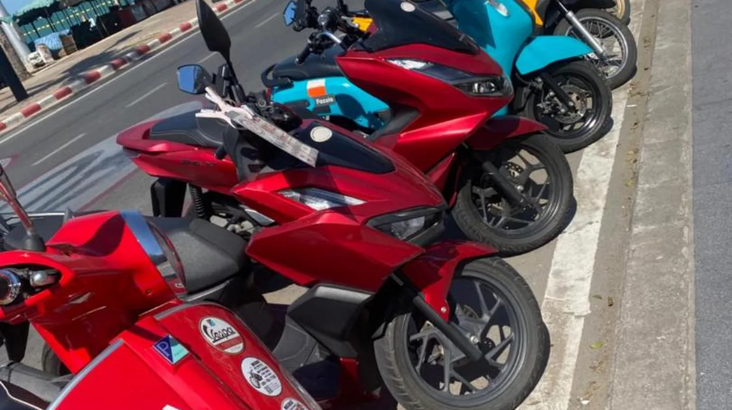 a row of motorcycles parked next to a street at Downtown Oasis 芭提雅市中心独栋泳池别墅 A 5卧6卫 KTV BBQ 芭提雅海滩步行街500m in Pattaya South