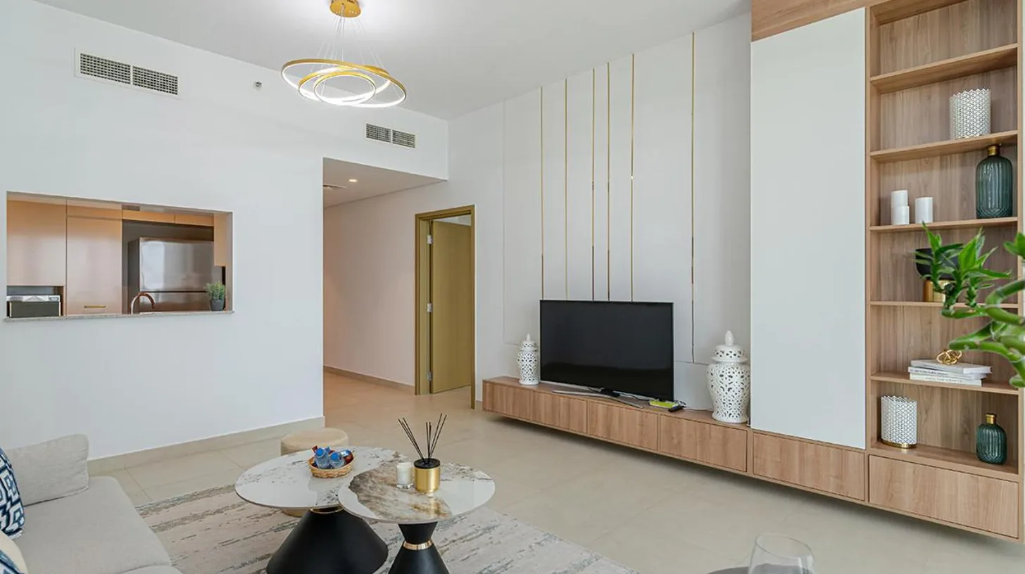 a white bedroom with a white bed with blue pillows at Downtown Views 4702 in Dubai