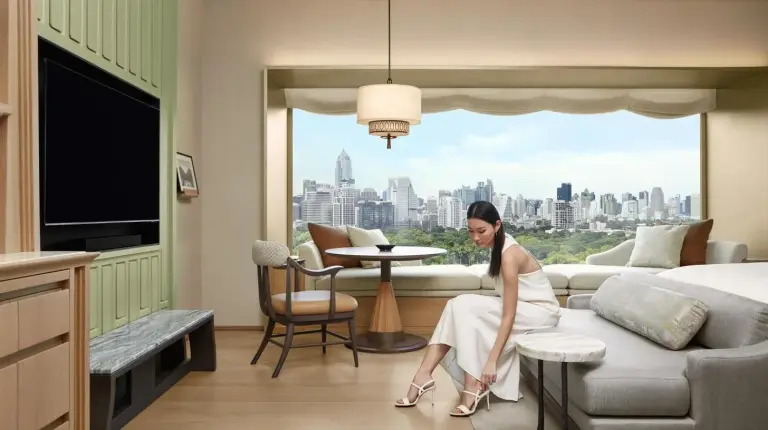 two beds in a room with a large window at Dusit Thani Bangkok in Bangkok