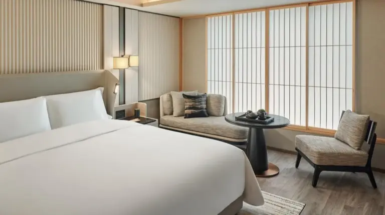 ein Schlafzimmer mit großem Bett und Wohnbereich im Dusit Thani Kyoto in Kyoto