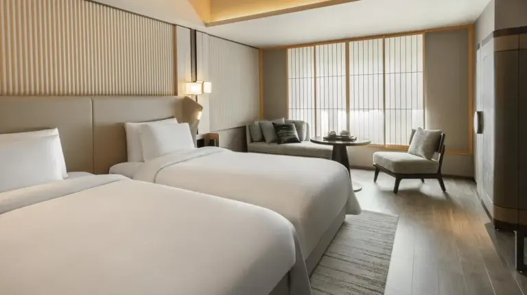 ein Hotelzimmer mit zwei Betten und einem Stuhl im Dusit Thani Kyoto in Kyoto