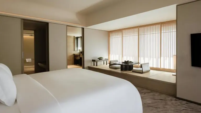 ein Schlafzimmer mit großem weißem Bett und großem Fenster im Dusit Thani Kyoto in Kyoto