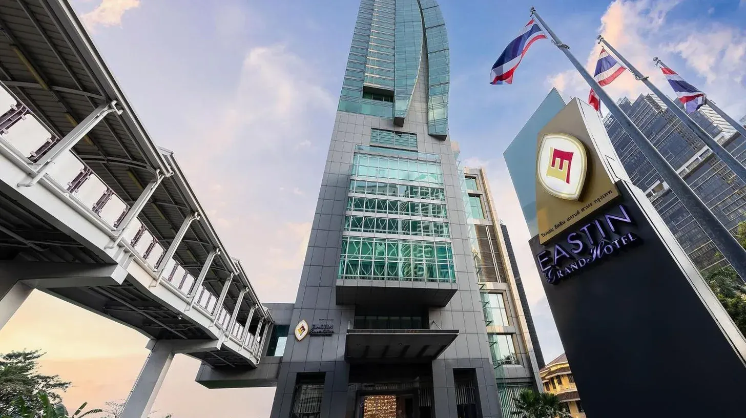 un grand bâtiment avec un panneau devant à l'Eastin Grand Hotel Sathorn à Bangkok
