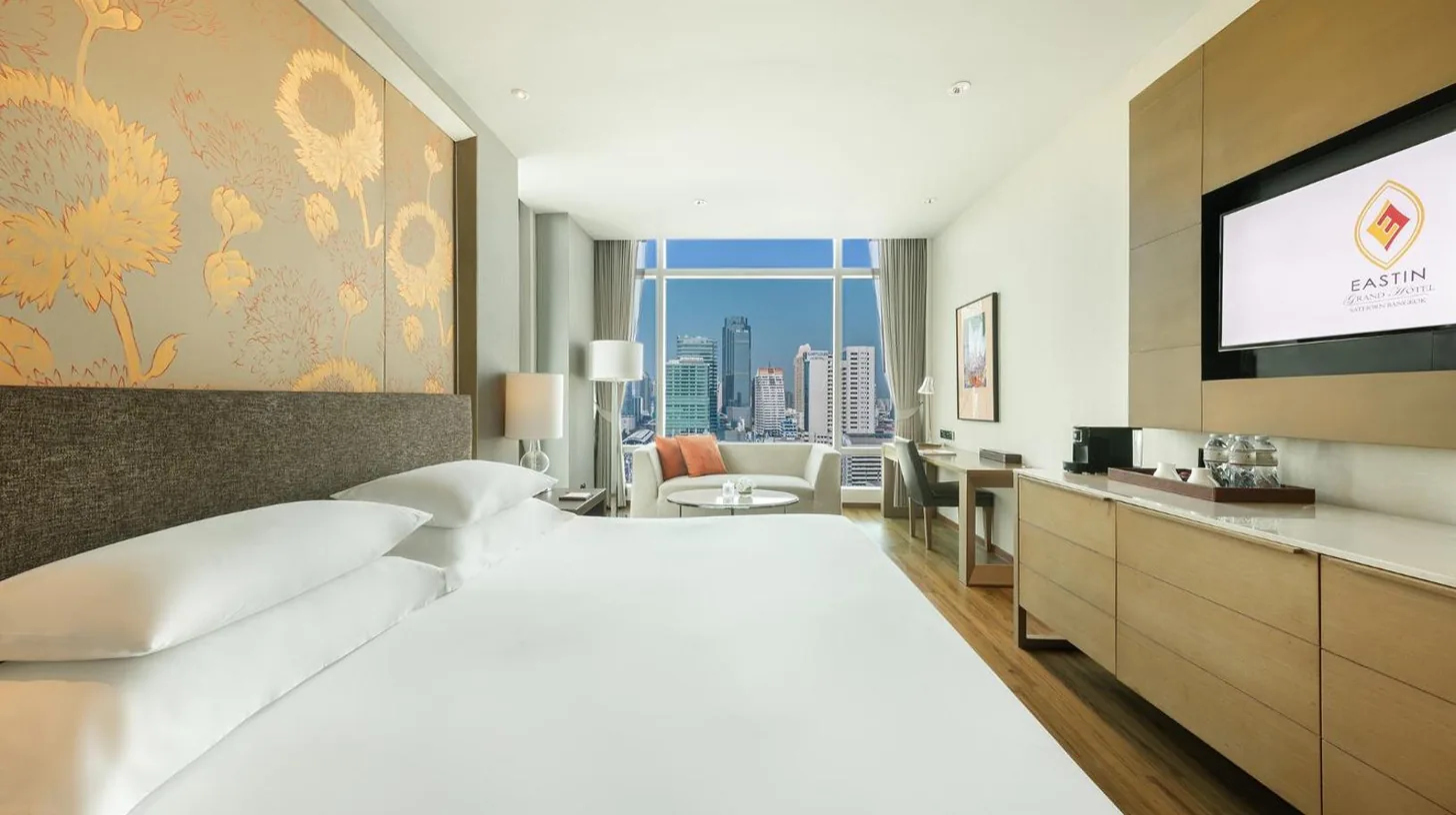 une salle de bain avec baignoire et grande fenêtre à l'Eastin Grand Hotel Sathorn à Bangkok
