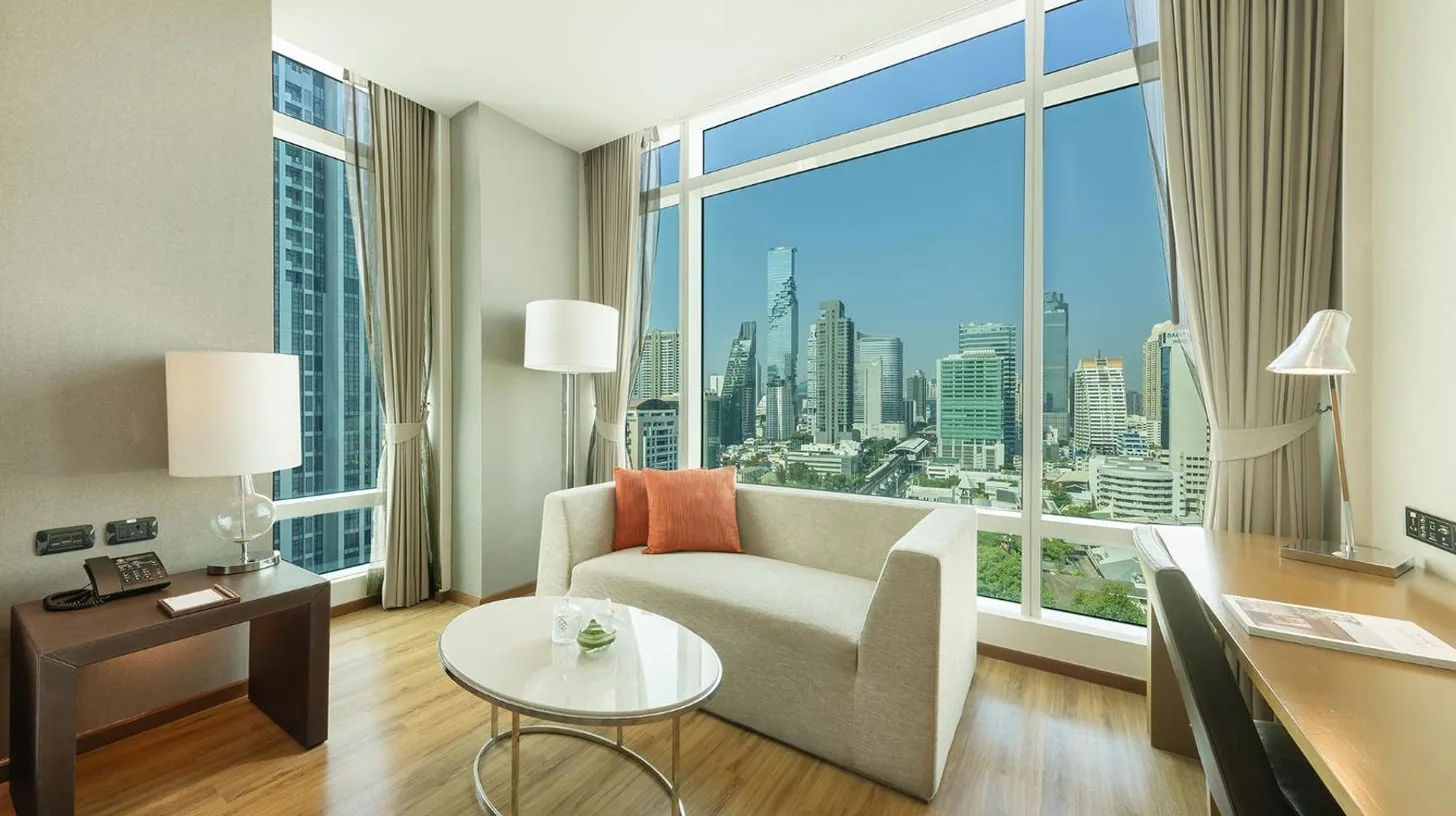 une salle de bain avec baignoire et grande fenêtre à l'Eastin Grand Hotel Sathorn à Bangkok