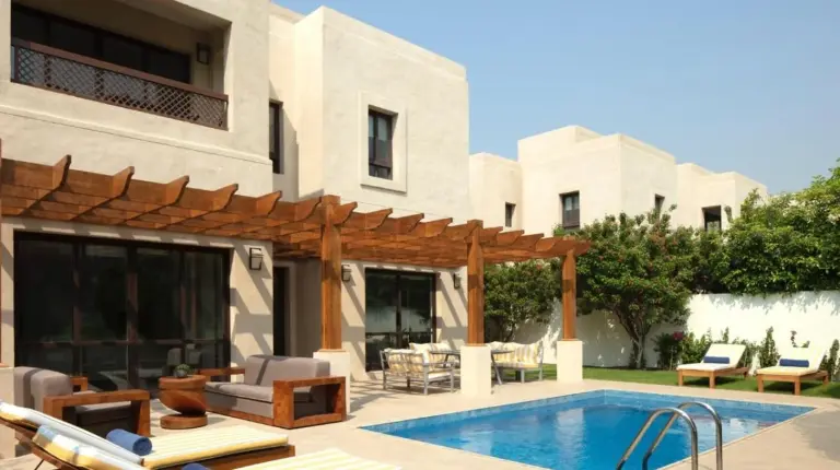 a swimming pool in front of a house at Elara & Golf Villas - curated by Park Hyatt Dubai in Dubai