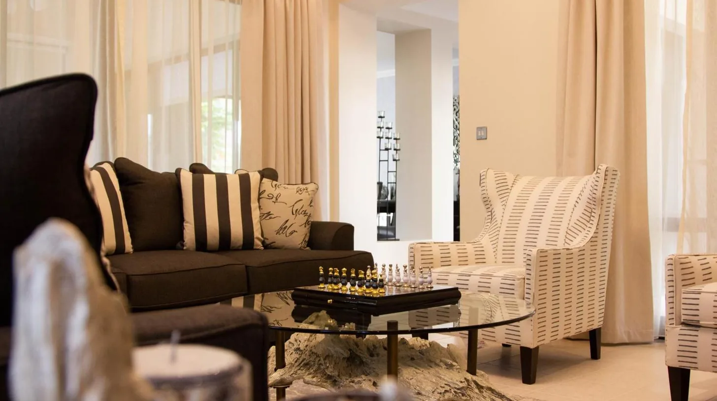 a living room with a couch and a table and chairs at Elara & Golf Villas - curated by Park Hyatt Dubai in Dubai
