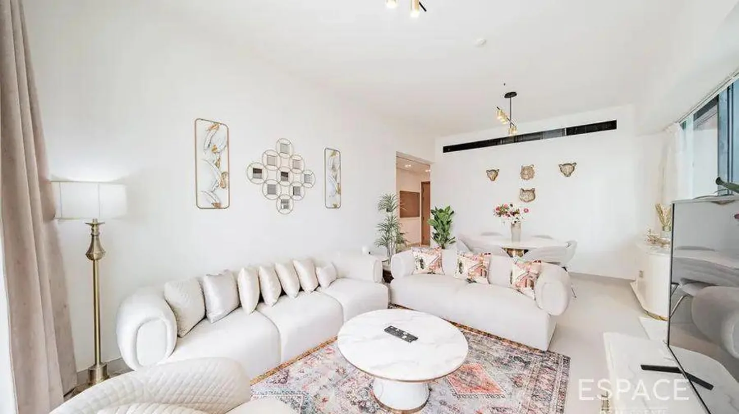 a white living room with a white couch and a table at Elegant 2BR Private Pool Apart At Binghatti Orchid JVC in Dubai