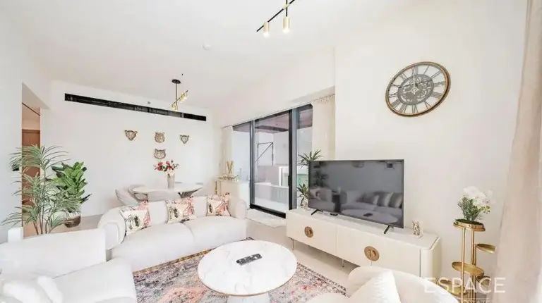 a living room with white furniture and a tv at Elegant 2BR Private Pool Apart At Binghatti Orchid JVC in Dubai