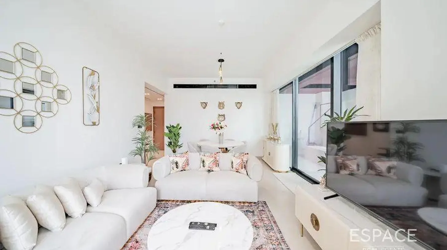 a living room with white furniture and a large window at Elegant 2BR Private Pool Apart At Binghatti Orchid JVC in Dubai