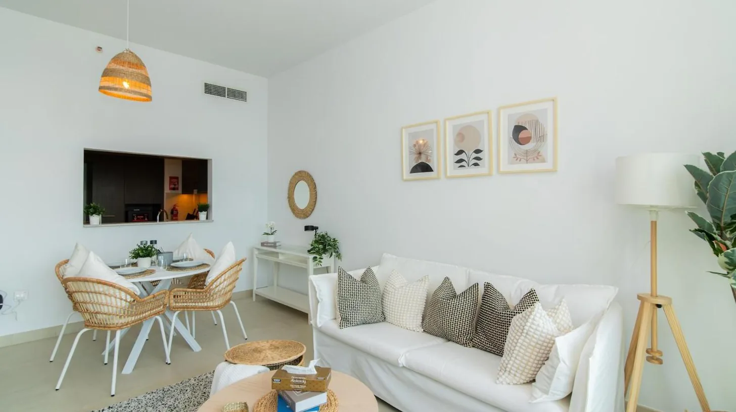 una sala de estar con un sofá blanco y una mesa en Elite Escape Holiday Home - 2 BHK Getaway with Burj Khalifa View and Dubai Mall Access - 1504 en Dubái