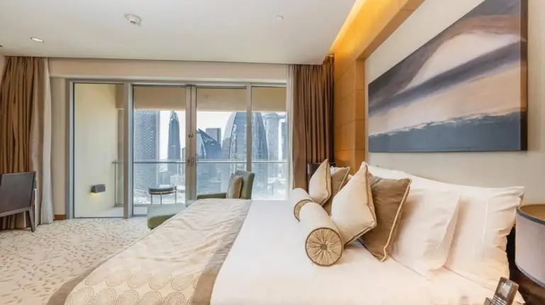 a bedroom with a large bed and a large window at Emaar Fashion Avenue - Formerly Address Dubai Mall Four Apple in Dubai