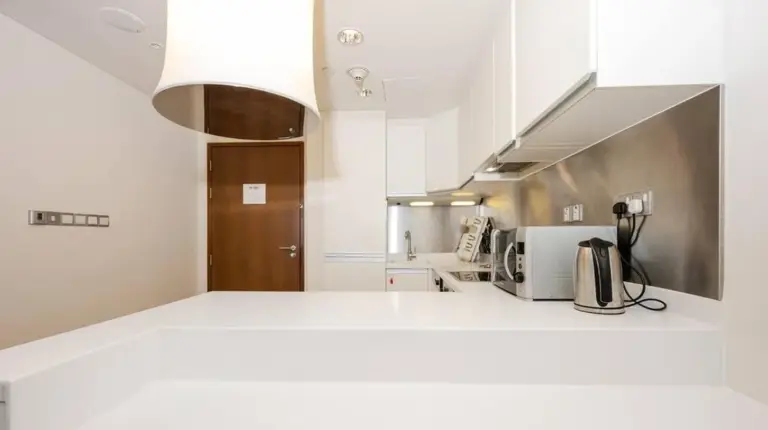 a kitchen with white counters and a white counter top at Emaar Fashion Avenue - Formerly Address Dubai Mall Four Apple in Dubai