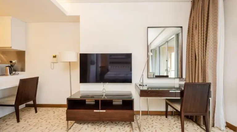 a hotel room with a desk and a mirror at Emaar Fashion Avenue - Formerly Address Dubai Mall Four Apple in Dubai
