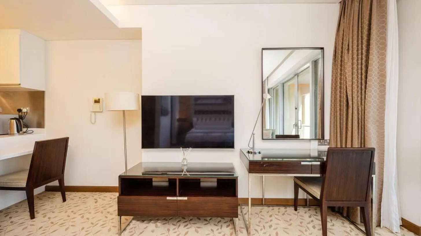 a hotel room with a desk and a mirror at Emaar Fashion Avenue - Formerly Address Dubai Mall Four Apple in Dubai