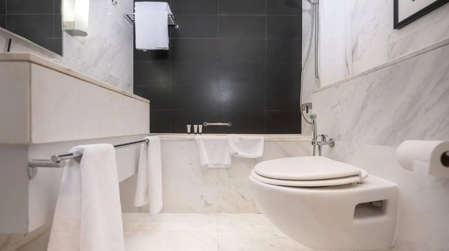 a white bathroom with a toilet and a bath tub at Emaar Fashion Avenue - Formerly Address Dubai Mall Four Apple in Dubai