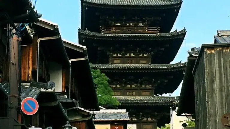 a large building in the background with people walking down a street at EnSe Kiyomizu Villa in Kyoto