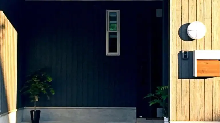 a building with a green wall and stairs in front at EnSe Kiyomizu Villa in Kyoto