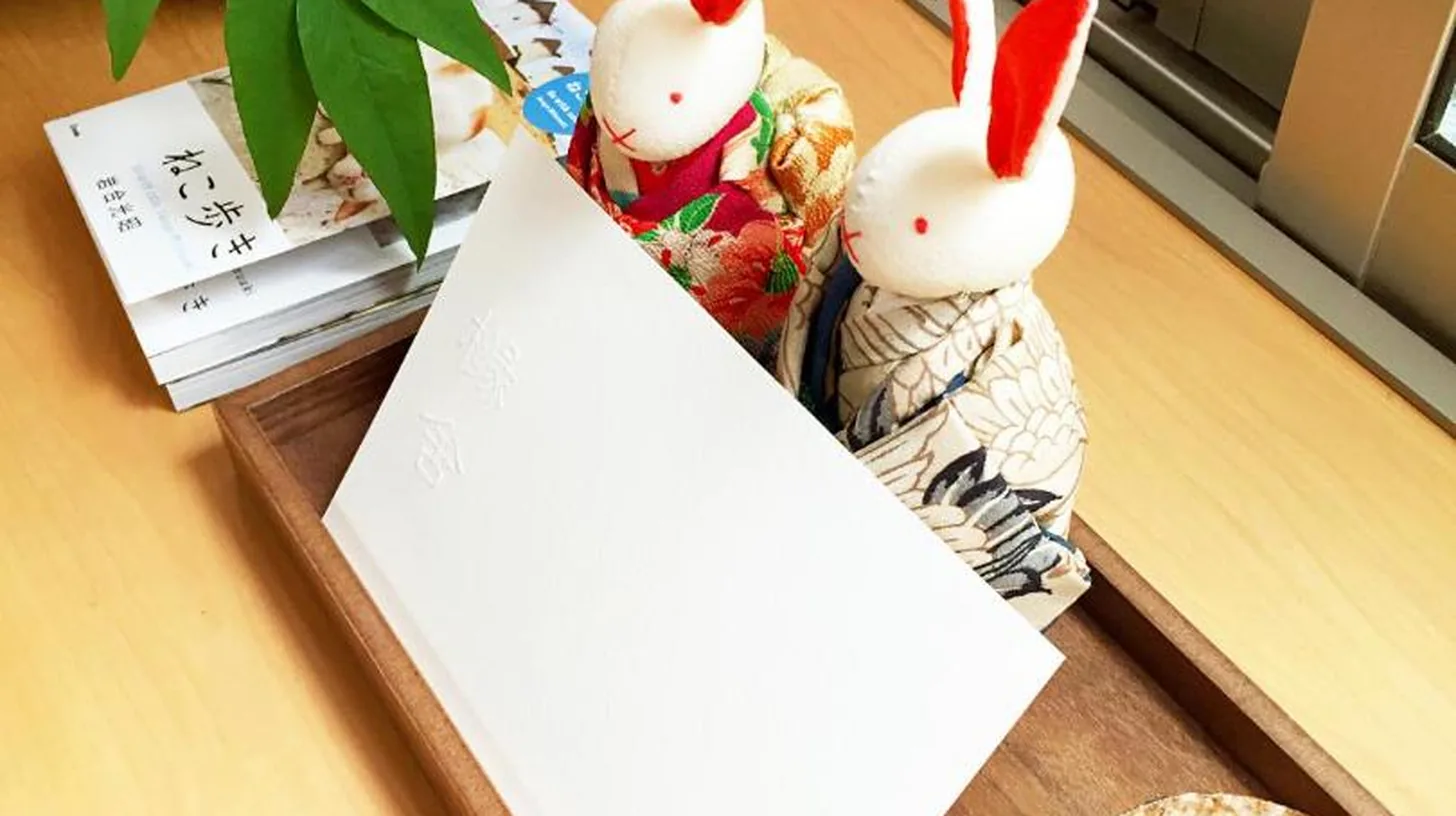 two bunny figurines sitting on a table with a sign at EnSe Kiyomizu Villa in Kyoto