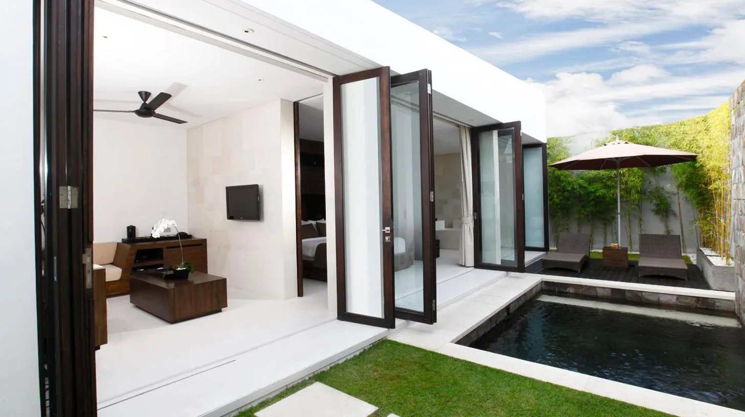 an external view of a house with a swimming pool at eqUILIBRIA Seminyak in Seminyak