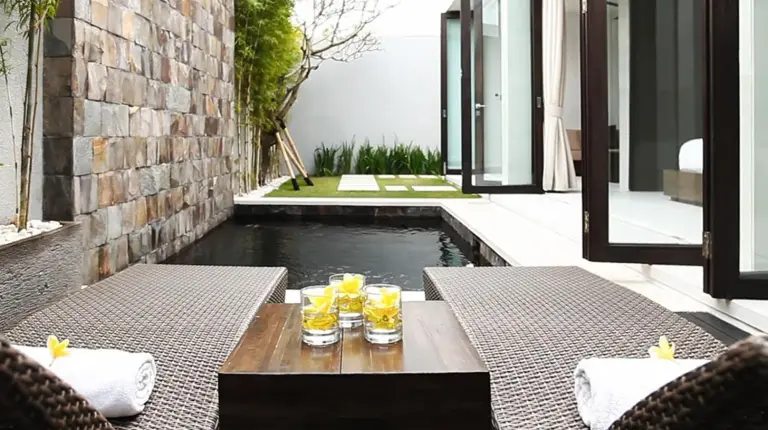 a table with drinks on it next to a pool at eqUILIBRIA Seminyak in Seminyak