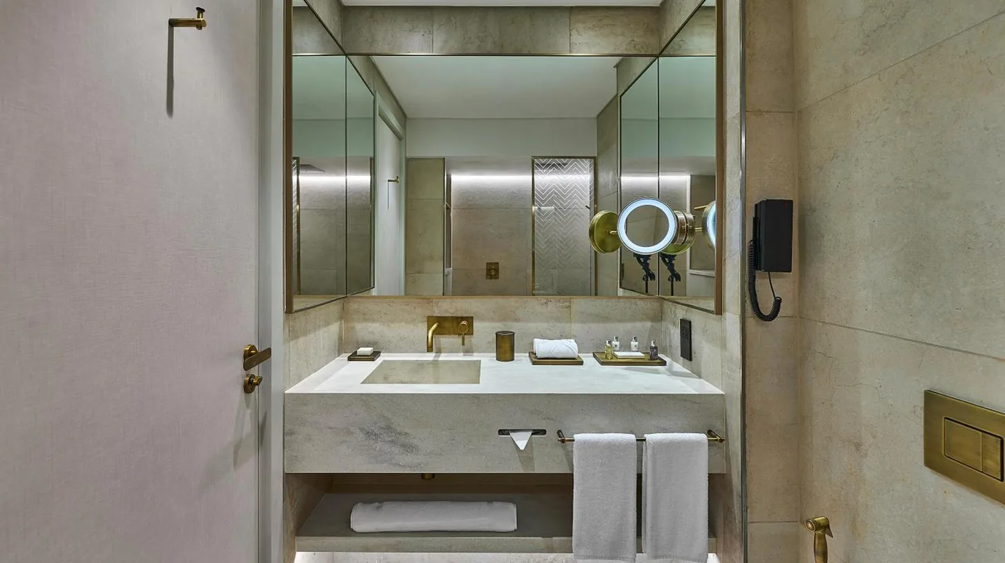 a bathroom with a sink and a large mirror at ERTH Abu Dhabi Hotel in Abu Dhabi