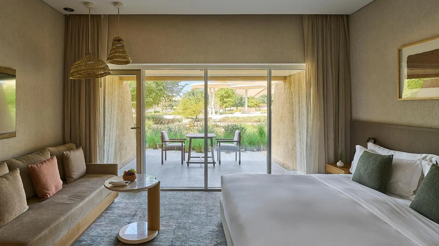 a hotel room with a large bed and a couch at ERTH Abu Dhabi Hotel in Abu Dhabi