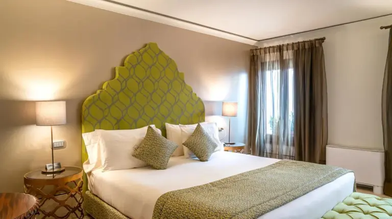 a bedroom with a large bed with the green headboard at Excess Venice Boutique Hotel & Private Spa - Adults Only in Venice